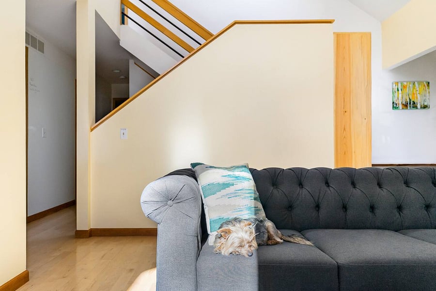 Staircase from primary living room area leading to basement and upstairs