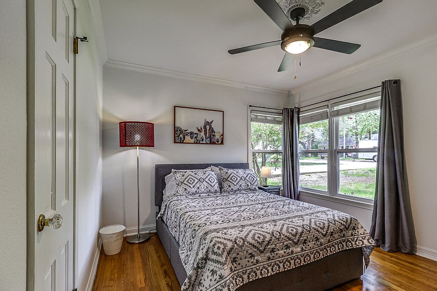 Second bedroom has a queen bed with closet, fan and large executive desk plus dresser, side tables and lamps. Blackout curtain and blinds for all bedroom windows.