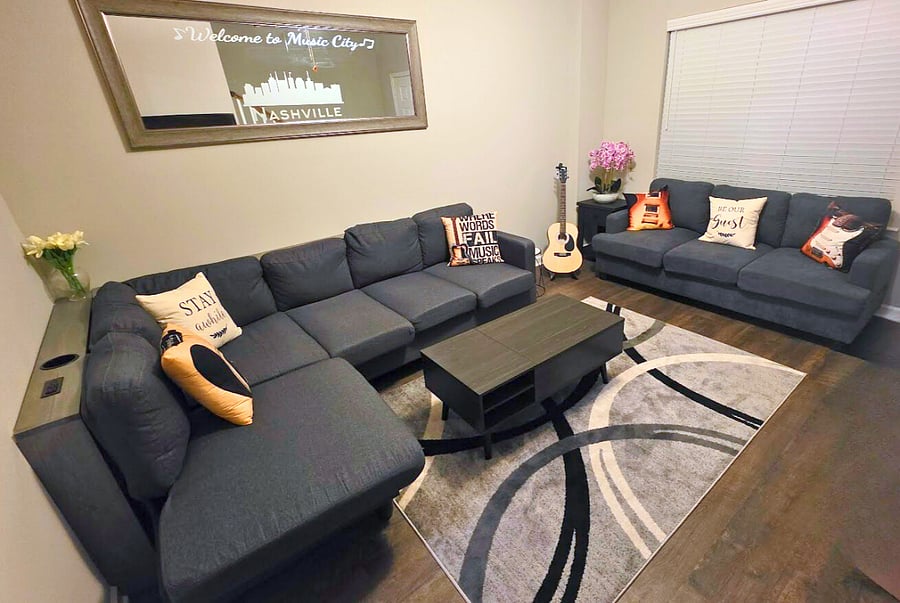 Large living area with pop up coffee table, drink holders, and a guitar!