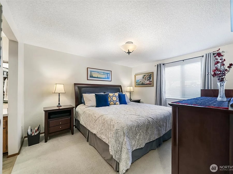 Primary bedroom has a king bed in it and dressers and a walk-in closet.