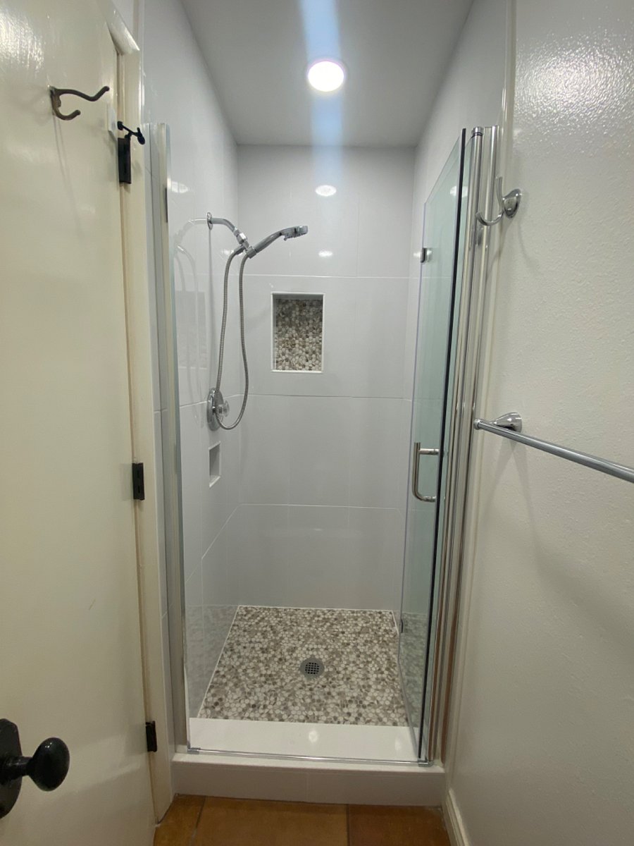 New tiled shower with niches and bifold easy entrance glass doorway. f