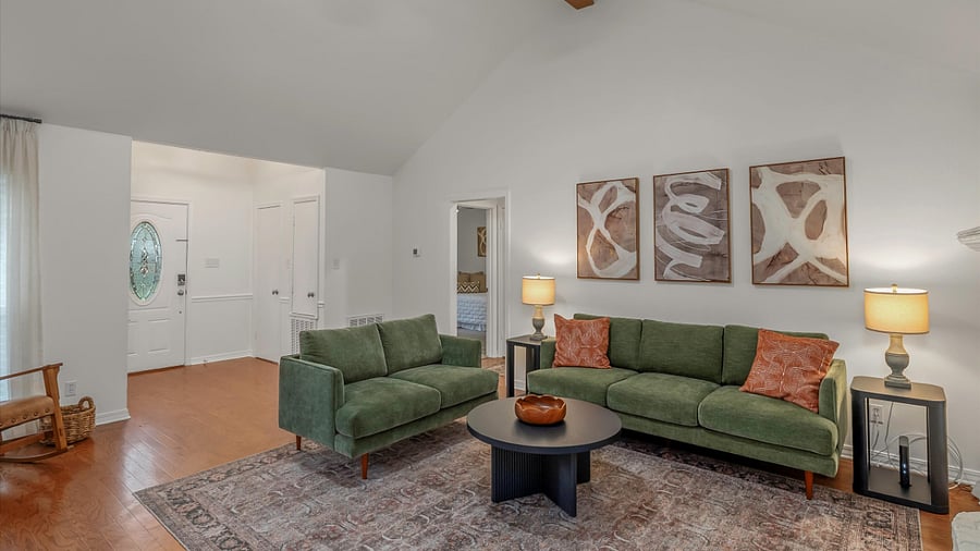 Large & open living room with vaulted ceilings, fan and natural light