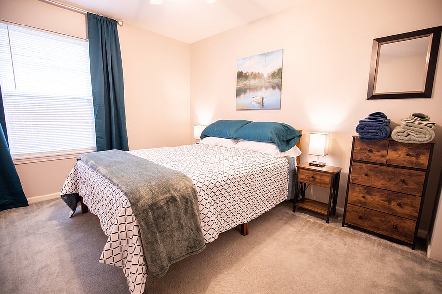 Queen bed room with closet and dresser; offers hooks for towels