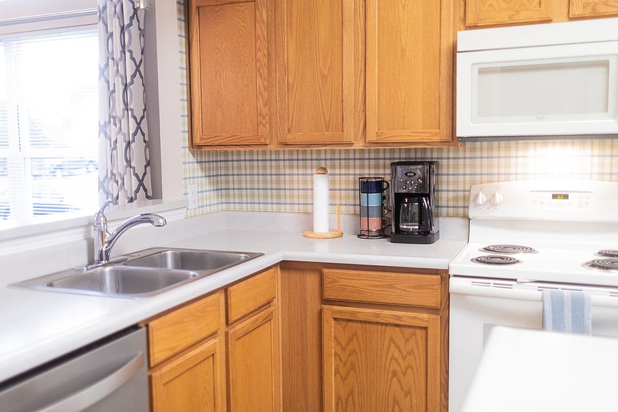 Nicely appointed kitchen with dishes, glassware, cutlery, and pots and pans; mixing, serving, and casserole dishes; crock pot; coffee maker