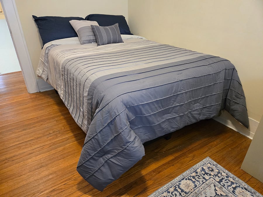 Third bedroom is snug (121 SQ ft) but has full-size bed, workstation, and plenty of storage: walk-in closet, shelves, credenza and dresser. Full length mirror, 3-prong outlets, area rug. Room darkening shades. Full bath is down the hall.