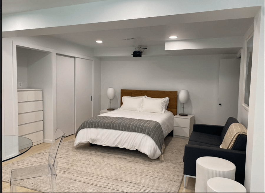 Bedroom with Seating Area and Ample Storage: Floor to Ceiling Closet and 6-Drawer Dresser.