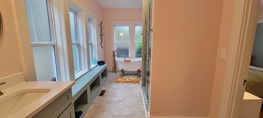 Main bathroom with shower, clawfoot tub, large bench, & vanity