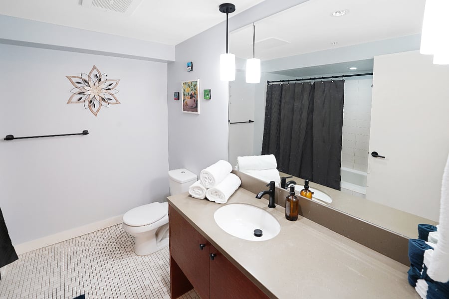Modern Bathroom Spacious layout with sleek vanity, ample storage, and shower/tub combo.
