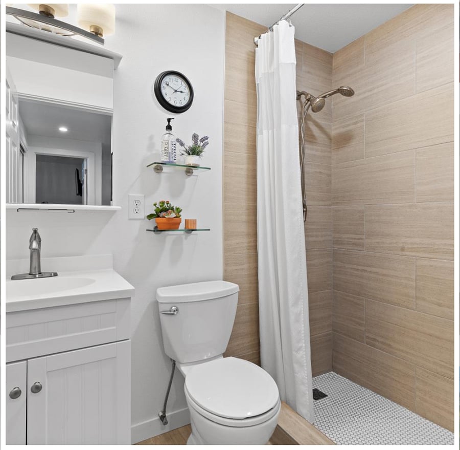 Enjoy a well-organized bathroom with storage under the sink, dual adjustable shower heads, and convenient wall shelving.