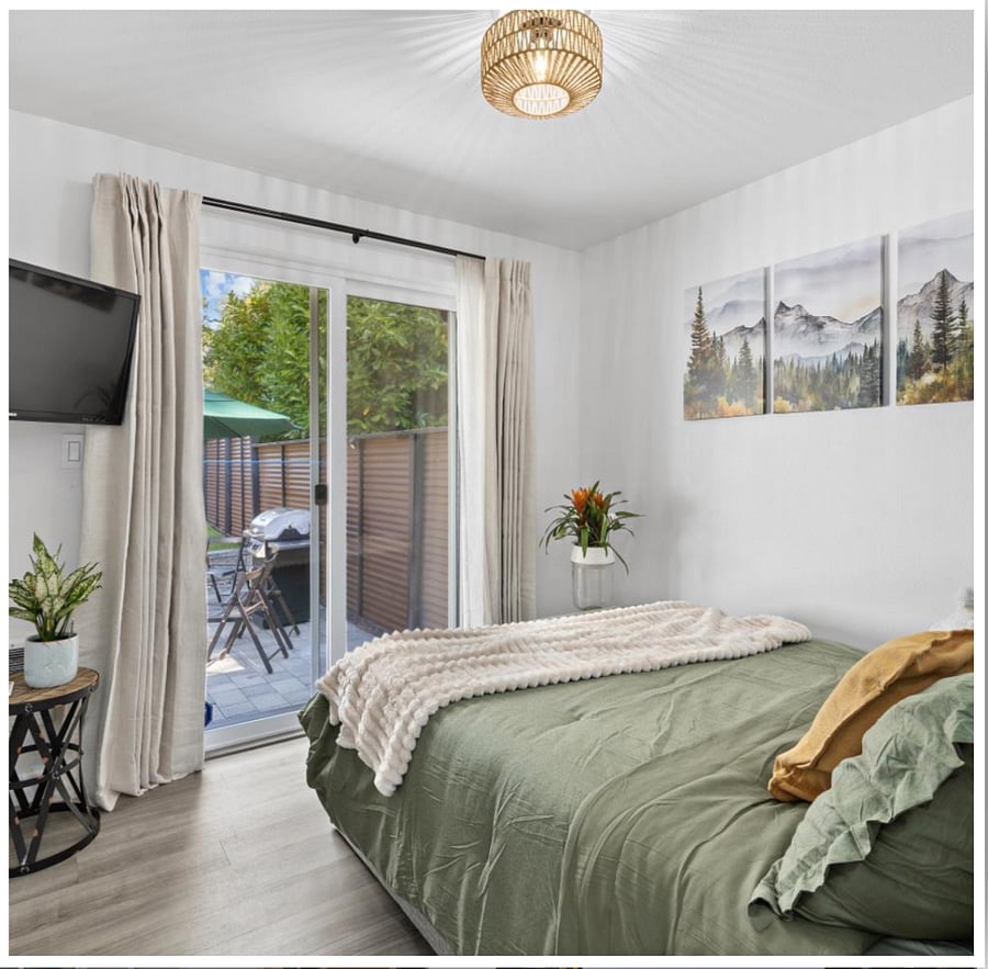 Second bedroom with direct access to the fully fenced backyard oasis opens the door for a breath of fresh air and the calming sound of swaying trees. Features blackout curtains for restful sleep and a 40 RCA smart TV for your entertainment