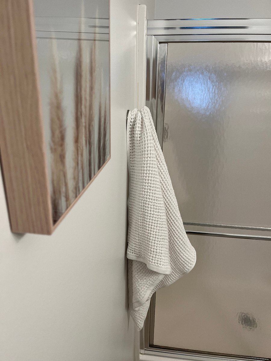 Spa bathroom features new white linens, hair dryer and walk-in shower.