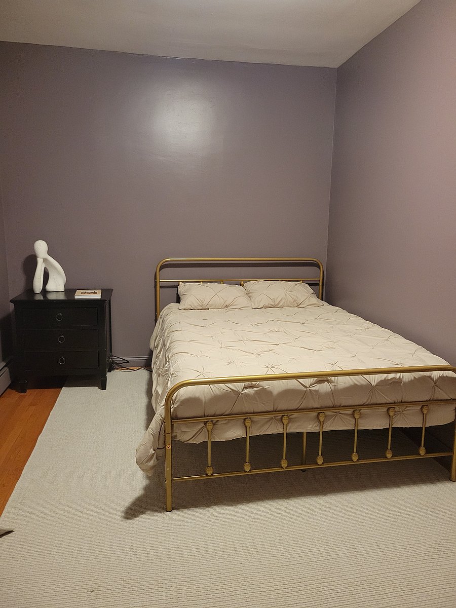 Bedroom with bed and nightstand featuring built-in electrical outlets.