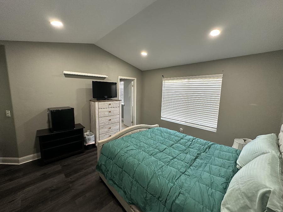 This master bedroom features a spacious walk-in closet, a private bath with dual shower heads, and a mini fridge for added convenience. A nightstand will also be added shortly.
