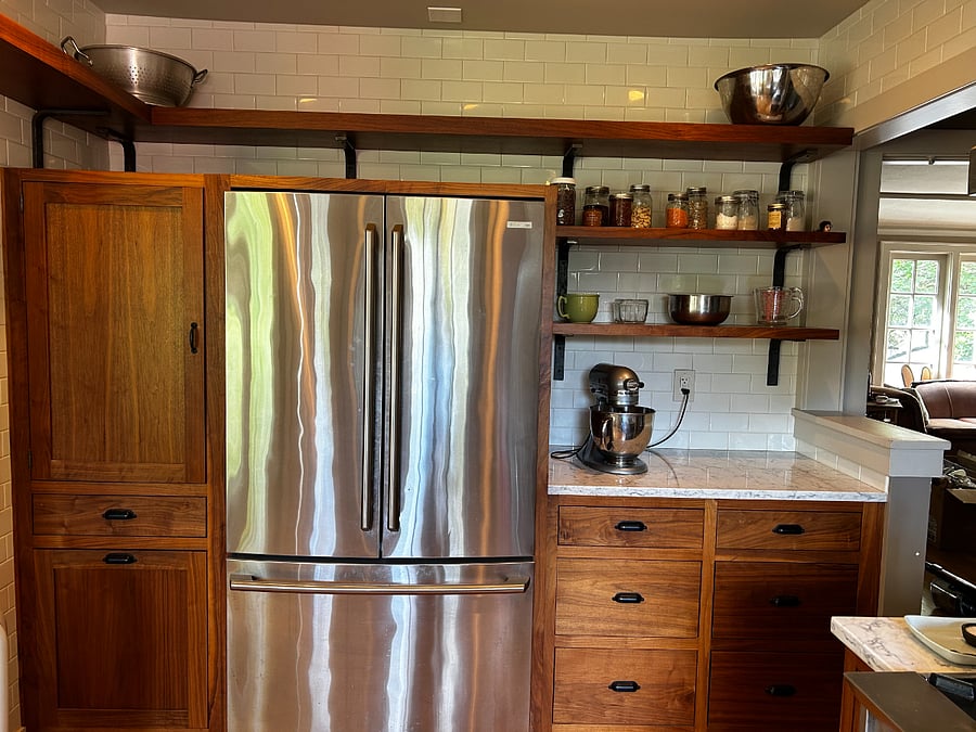 Fridge/freezer. Recycling drawers on the left; baking counter and storage on the right.