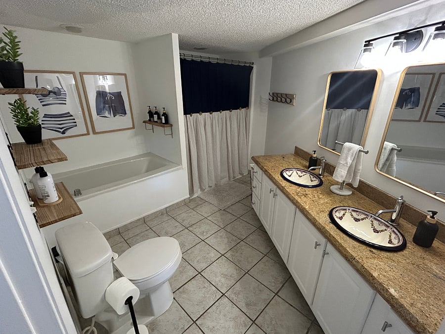 Bathroom 1 is a full-bath with separate shower and tub. It features a dual sink vanity. 