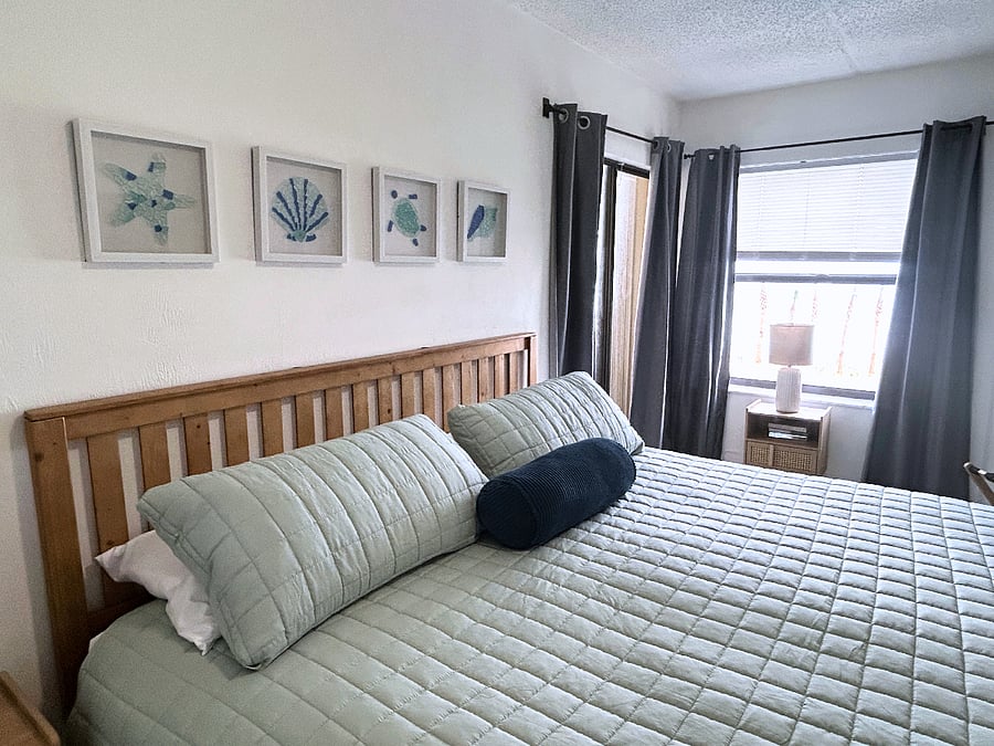 Bedroom 2 features a king-sized bed, a roomy closet, a TV, a ceiling fan and access to the balcony. 