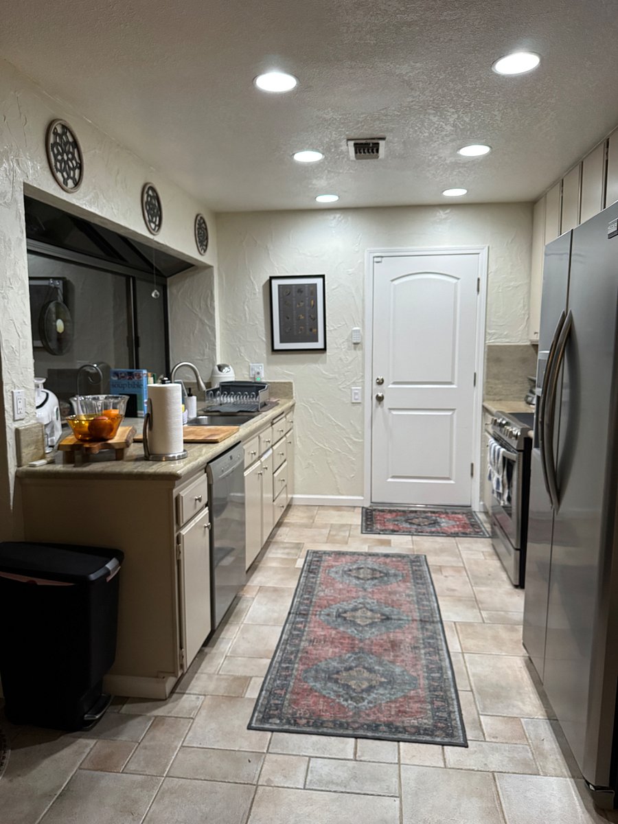 Kitchen and dishwasher on left, granite, big window looking into courtyard and door into garage