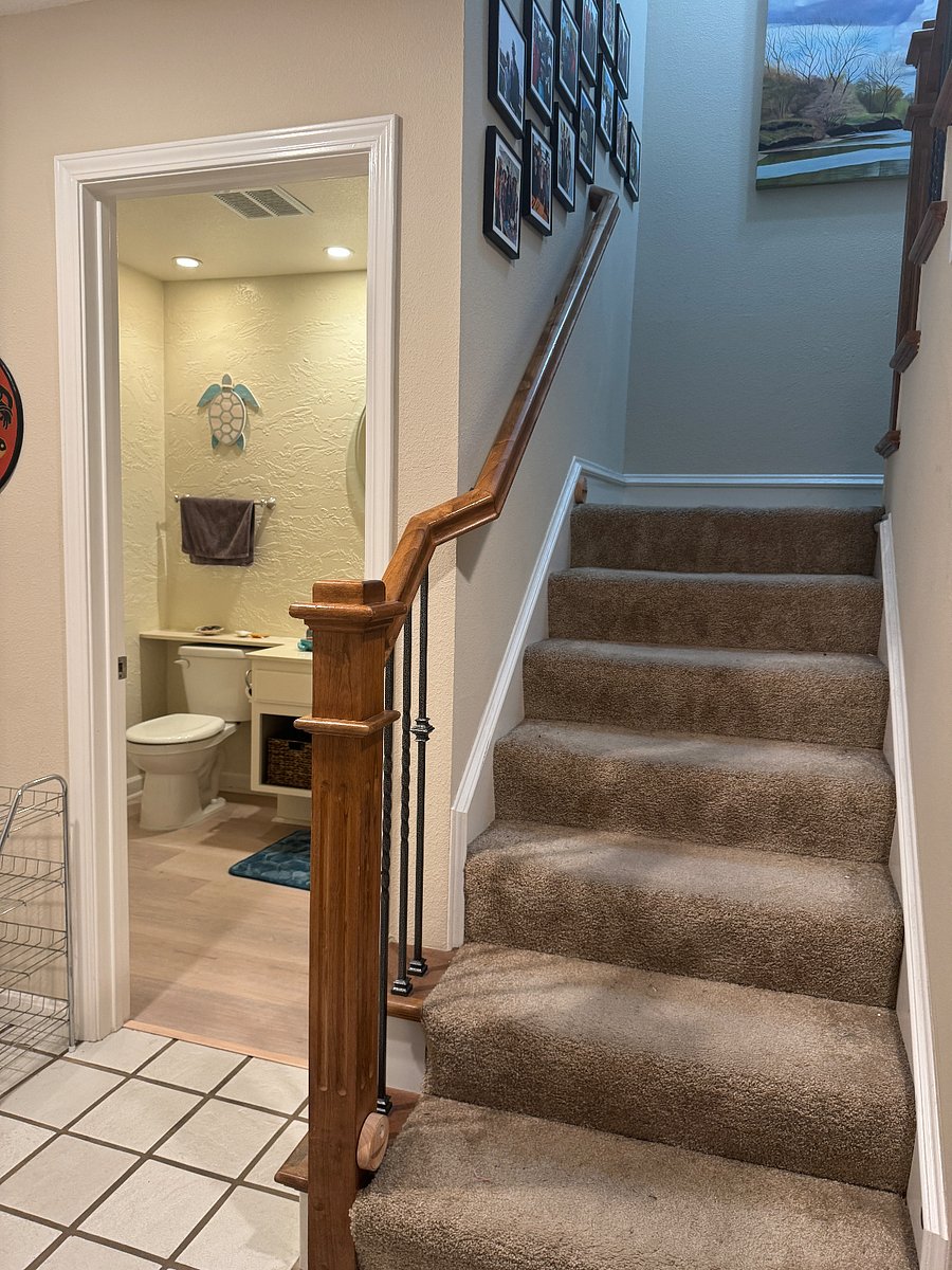 Stairs at front door next to guest bathroom