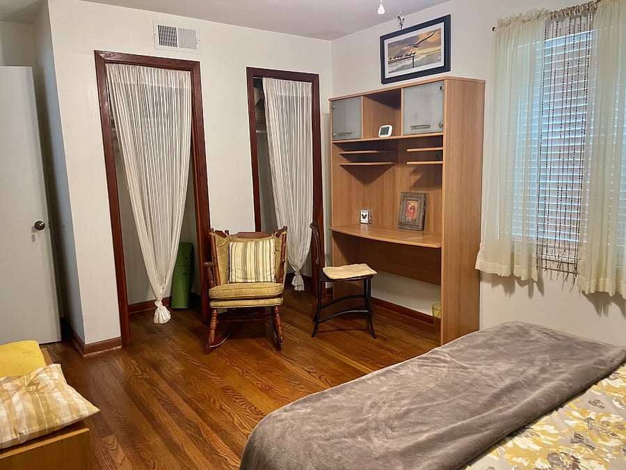 Yellow bedroom with closet space and desk.