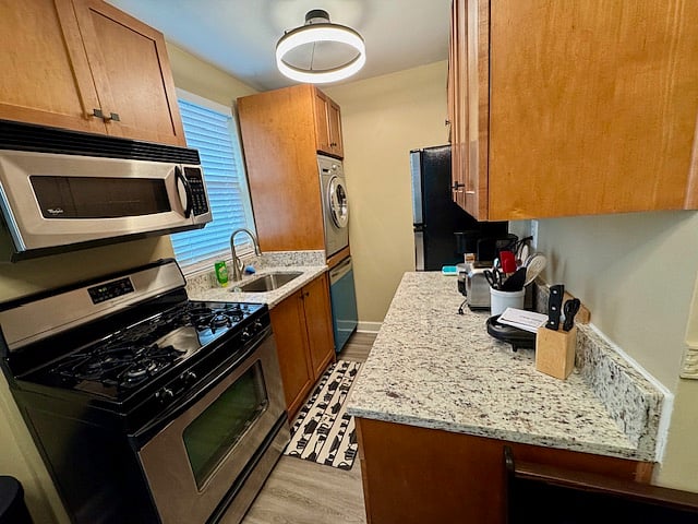 Kitchen comes equipped with gas range, microwave, dishwasher, All-in-One washer and dryer, and a refrigerator w/ top freezer. 