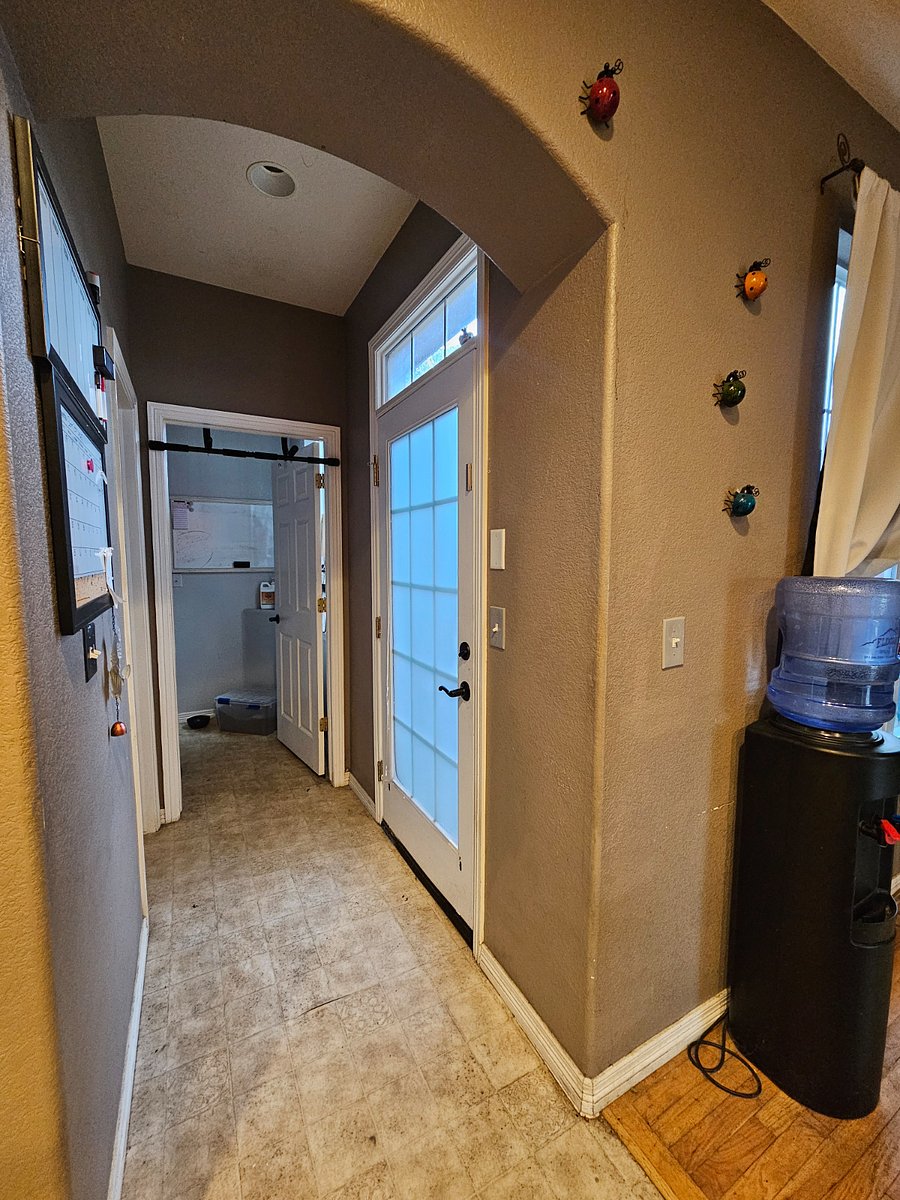 View from kitchen, looking at laundroom. Door to right leads to the home's private patio. Door to left it powder bathroom. 