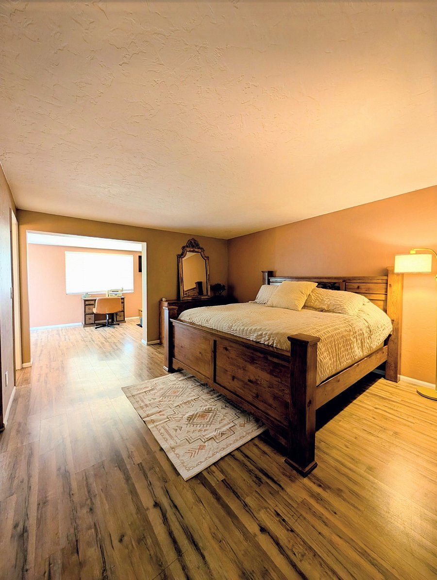 Primary bedroom with private working space, TV and pullout futon with extra blankets, and an onsuite full bathroom with standing shower 