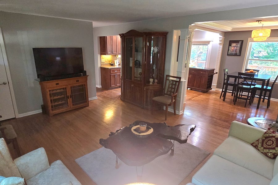 Comfortable living area with 55" smart TV and open flow to dining and kitchen spaces.