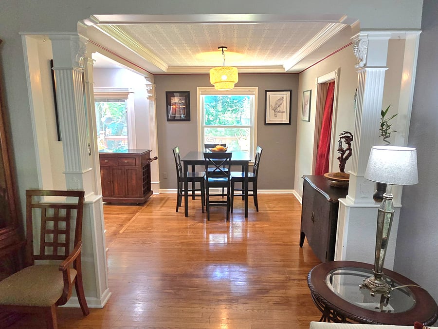 Dining room with seating for four, ideal for meals or workspace, adjoining kitchen and living area.