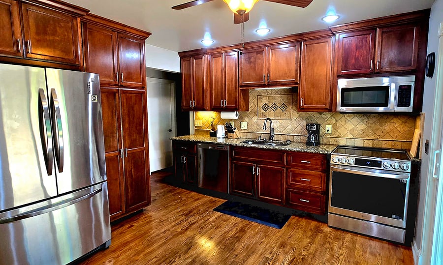 Fully stocked kitchen with stainless appliances, coffee maker, and all essentials for home cooking.