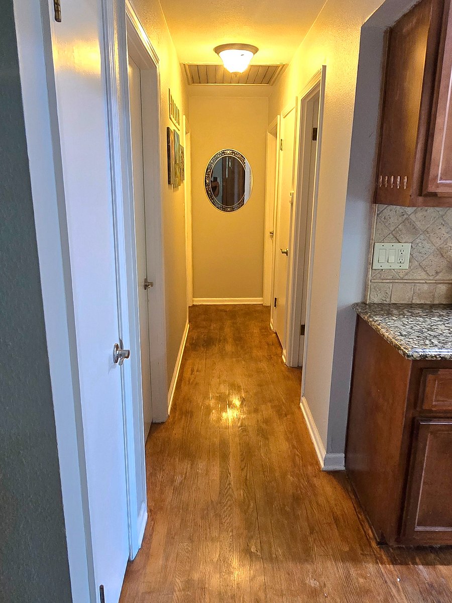 Hallway leading to bedrooms and main bath. Quiet, private area separated from living spaces.