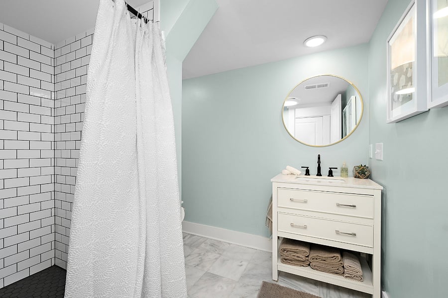 The large bathroom features a huge walk-in shower and marble floors.