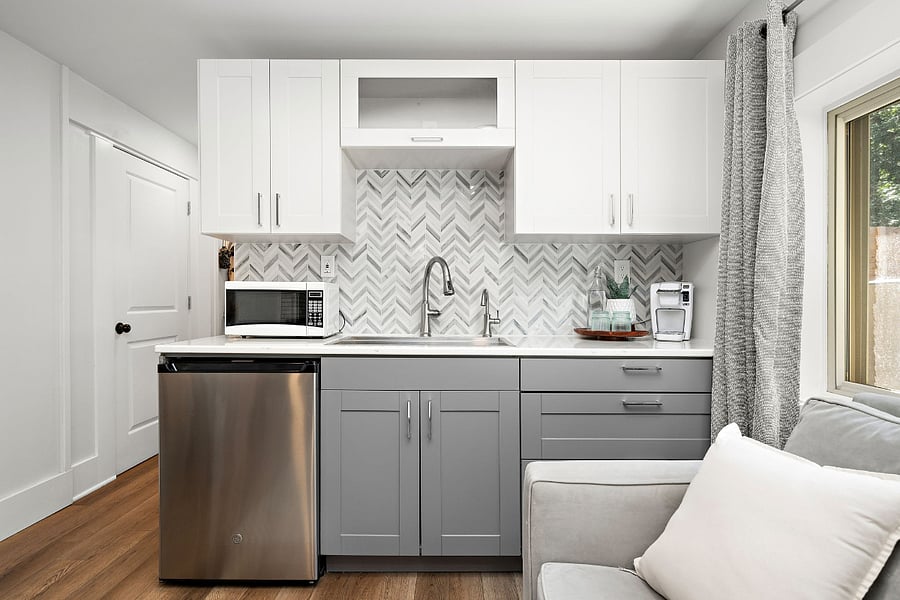 Kitchenette features a large, under counter refrigerator, quartz countertops, custom marble backsplash, microwave, Keurig, toaster oven, all all of the essentials.