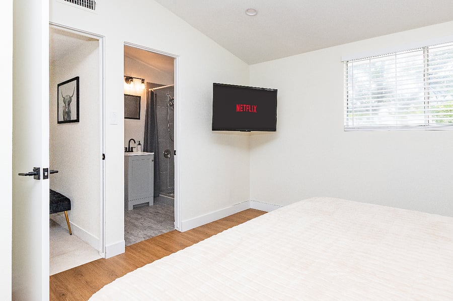 Bedroom view with private bath access and streaming TV