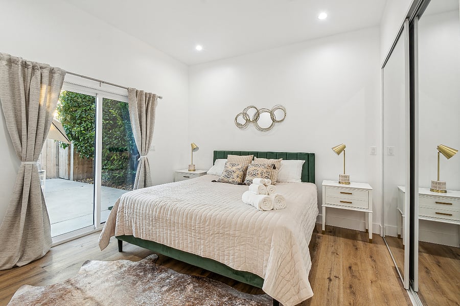 Private primary bedroom with patio access and quality bedding