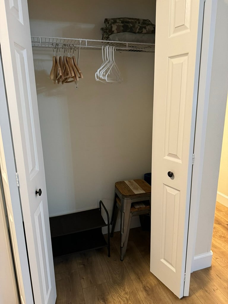 Coat closet in front room with shoe racks