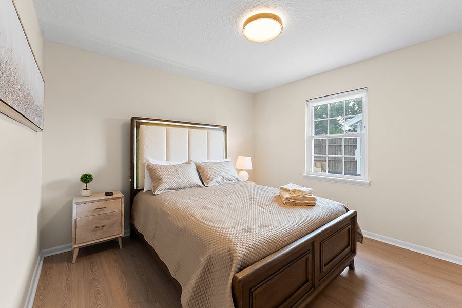 This serene bedroom features a supportive bed with luxe linens, a cozy comforter, smart TV, and full closet. Soft accent lighting adds a modern touch, while warm tones and plush textures create a calm, luxurious space for deep rest and recovery.