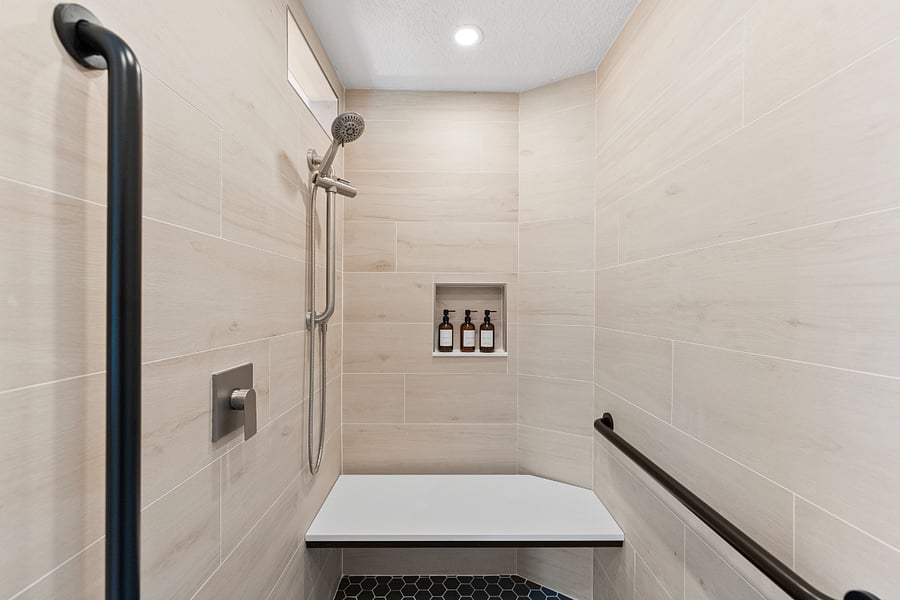 Spacious walk-in shower with bench, grab bars, and zero-step entrydesigned for mobility and comfort. A small transom window brings in natural light. A rare blend of accessibility and luxury in a serene, spa-like setting.