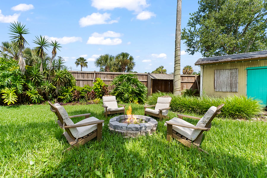 Cozy up around the stone firepitsurrounded by lush greenery and cushioned Adirondack chairs. A perfect spot to unwind, connect, and relax.