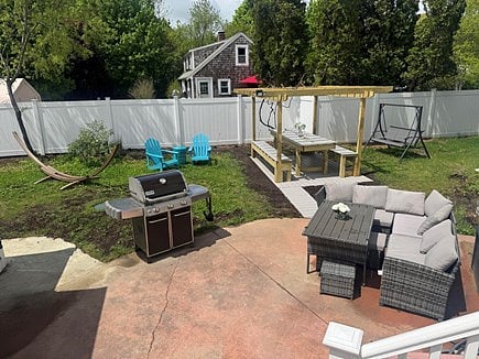 Backyard with pergola, lawn furniture, propane grill