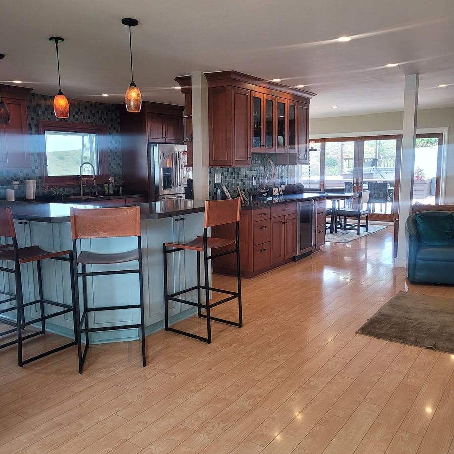 Open concept with kitchen, bar, dining and living room all within an airy space. 