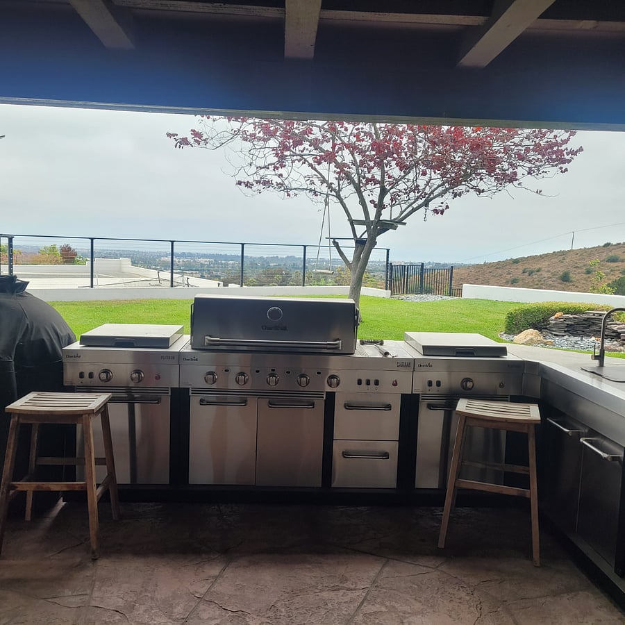 Outside kitchen with BBQ, cold sink, refrigerator, and Green Egg BBQ.