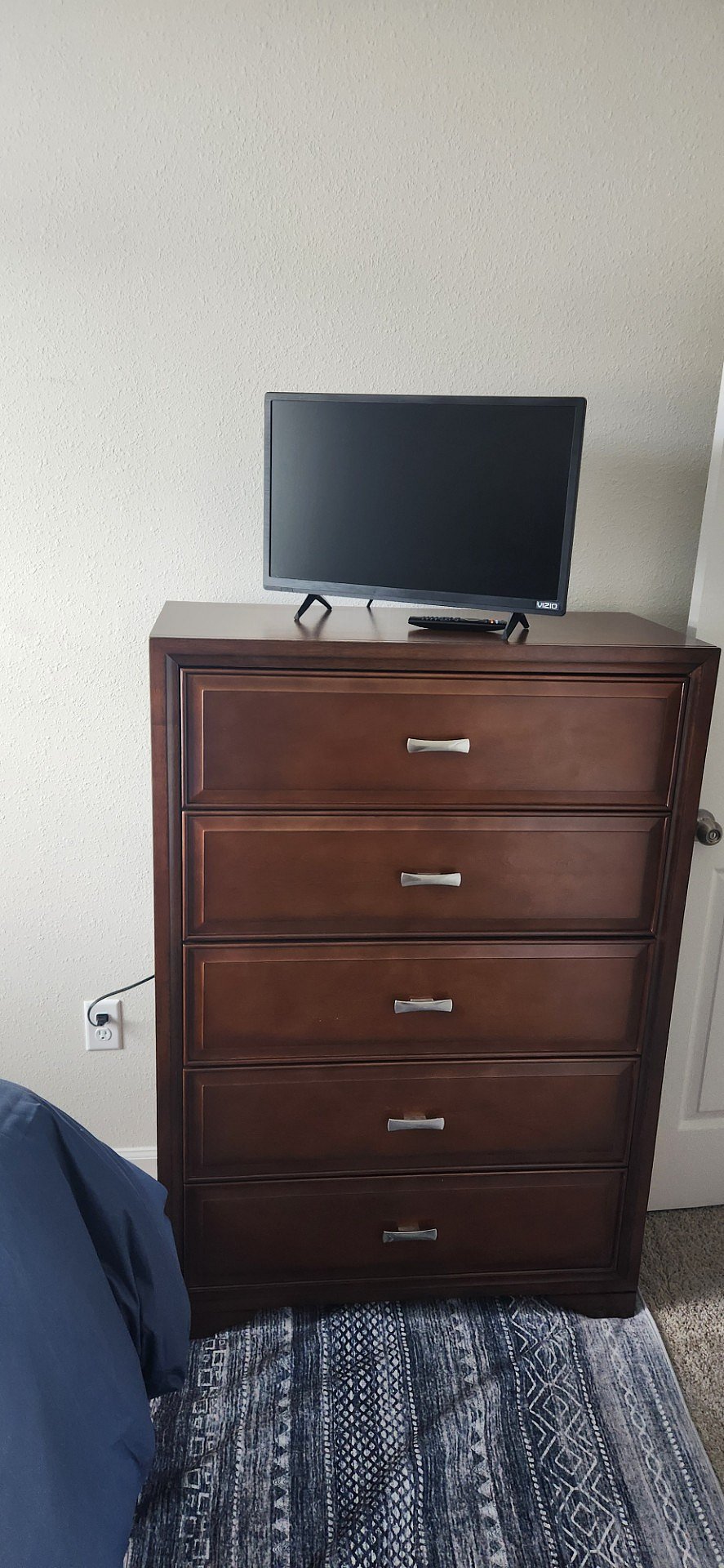 Chest of drawers in room with 32- inch smart TV
