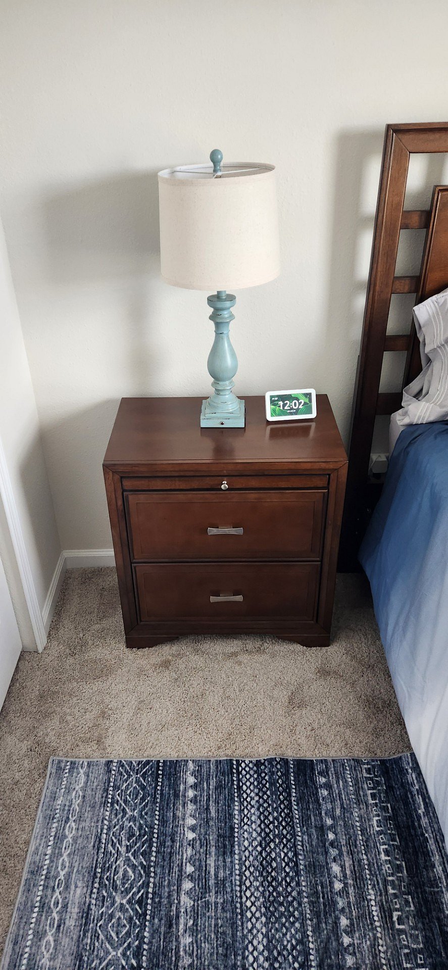 Nightstand in bedroom with lamp and Alexa