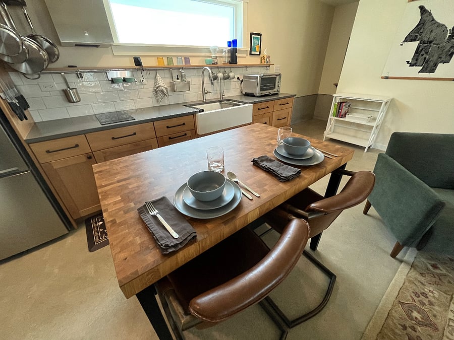 Dining side of island with stools and house dishes and flatware.