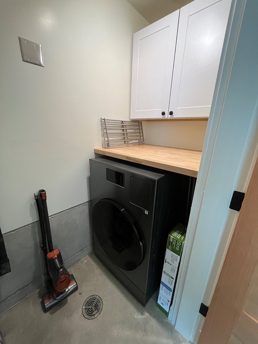 Downstairs utility and laundry closet with combined washer/drier.