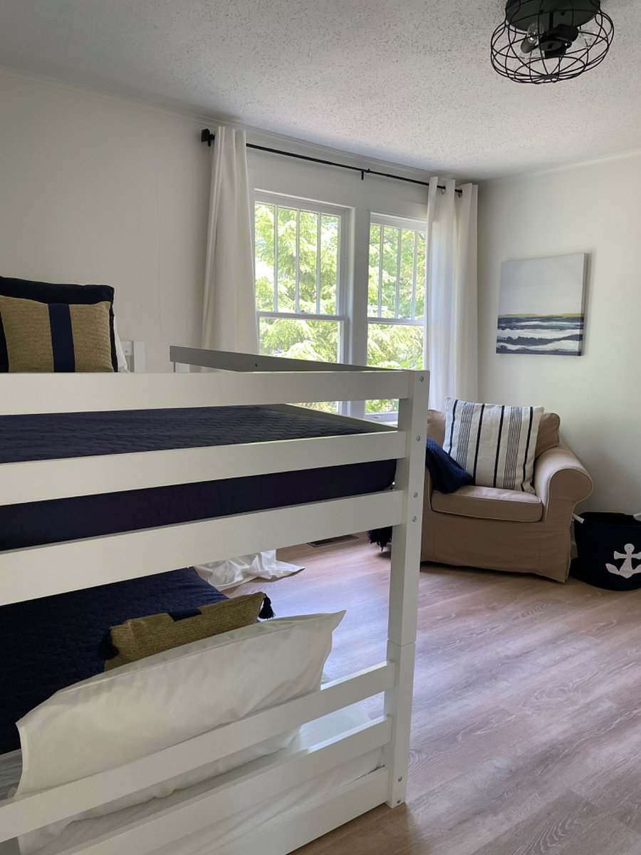 Transitional room between kitchen, bedroom and sunroom. Includes bunk beds and sitting chair