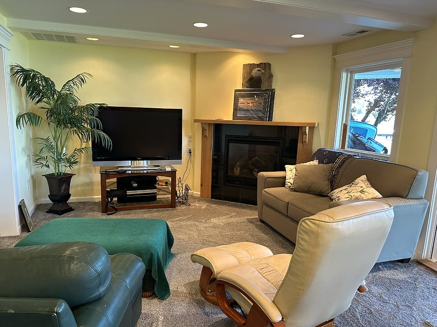 Lower level sitting area with gas fireplace and TV situated next to the kitchen.