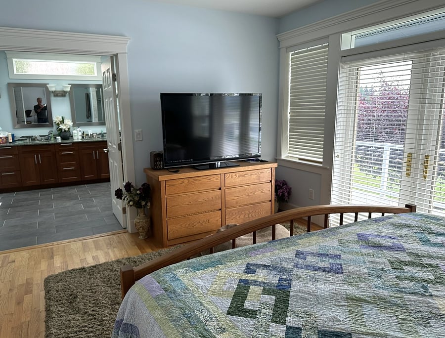 Primary suite with access to deck overlooking the lake.