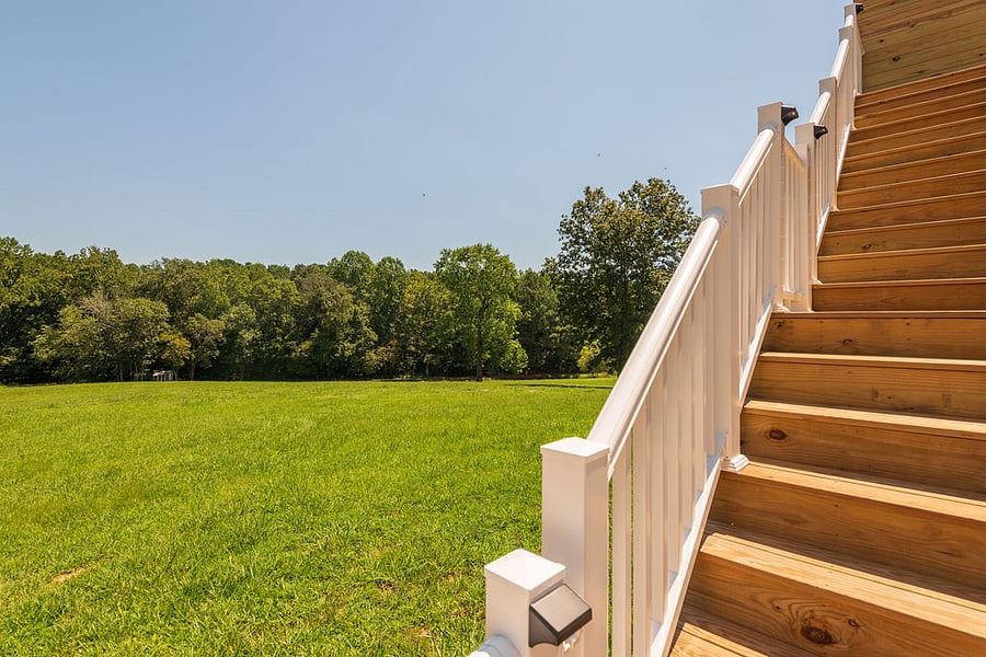 The back of the property is wide open grass, woods, and a creek.