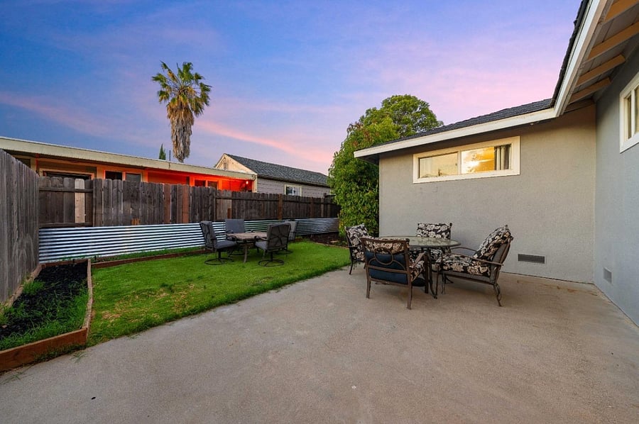 Private backyard with half concrete, half artificial grass. One Outdoor 4 chair-Glass table with Umbrella shade. 2nd Outdoor 4 chair-table with Optional fire pit.